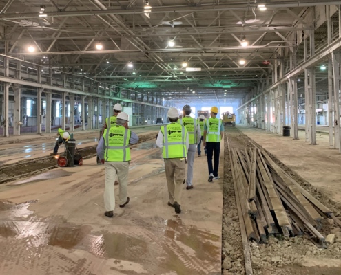 Back view of several construction workers walking through a site