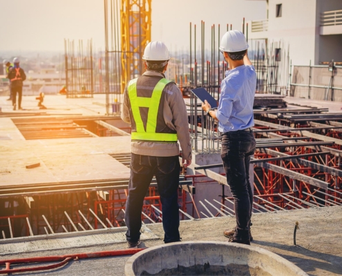 Construction engineers reviewing progress on industrial project.