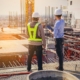 Construction engineers reviewing progress on industrial project.