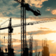 Silhouette of crane construction building towers at sunset